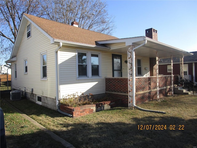 view of front facade featuring cooling unit, a front lawn, and a porch