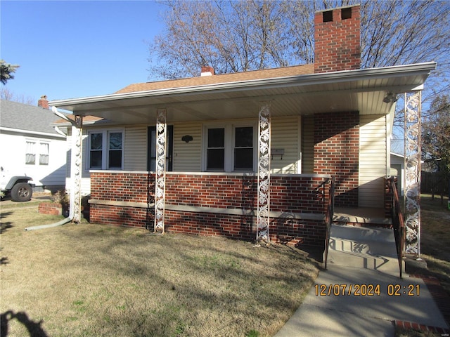 view of front of house with covered porch and a front lawn