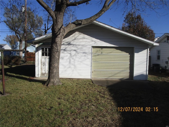 exterior space with an outbuilding, a garage, and a lawn