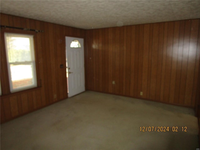 foyer entrance featuring wooden walls and a textured ceiling