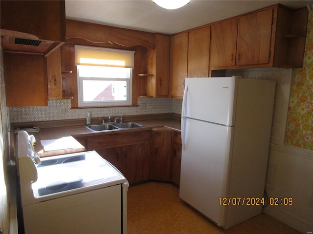 kitchen featuring stove, sink, and white fridge