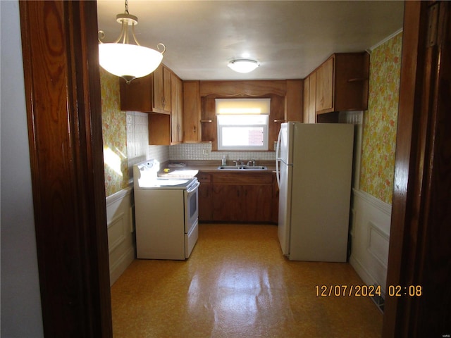 kitchen featuring tasteful backsplash, white appliances, decorative light fixtures, and sink