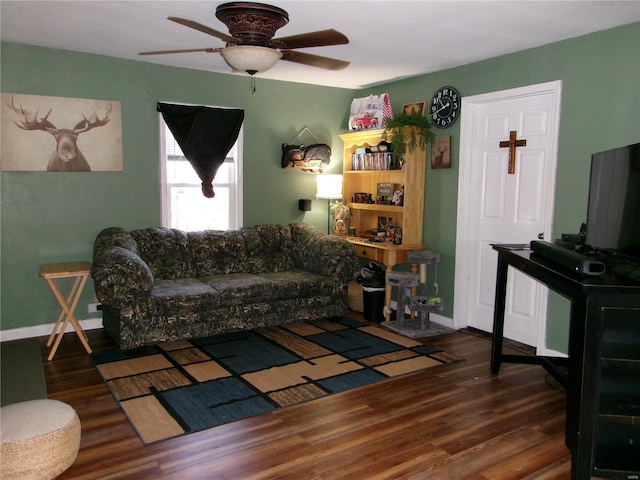 living room featuring ceiling fan and dark wood-type flooring