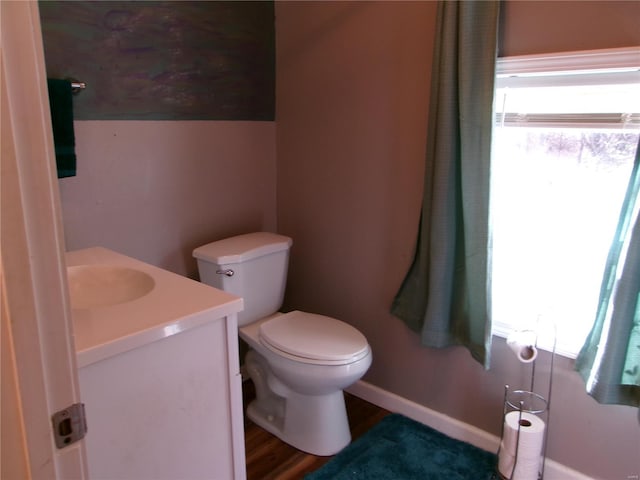 bathroom featuring wood-type flooring, vanity, and toilet