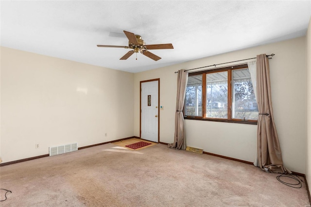 carpeted spare room with ceiling fan