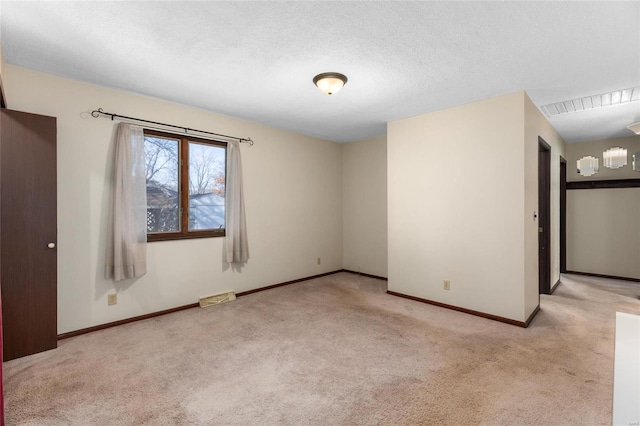 unfurnished room featuring a textured ceiling and light colored carpet