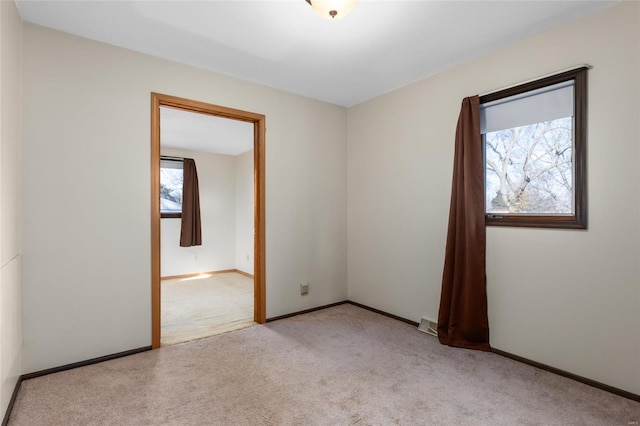 carpeted spare room featuring a healthy amount of sunlight