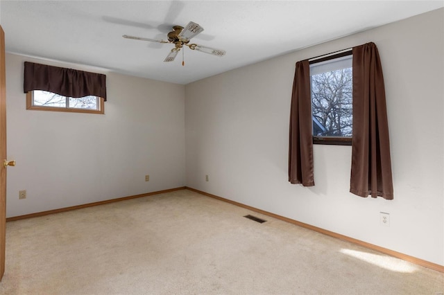 carpeted empty room featuring plenty of natural light and ceiling fan