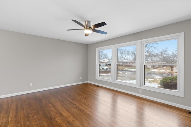 spare room with dark hardwood / wood-style flooring and ceiling fan