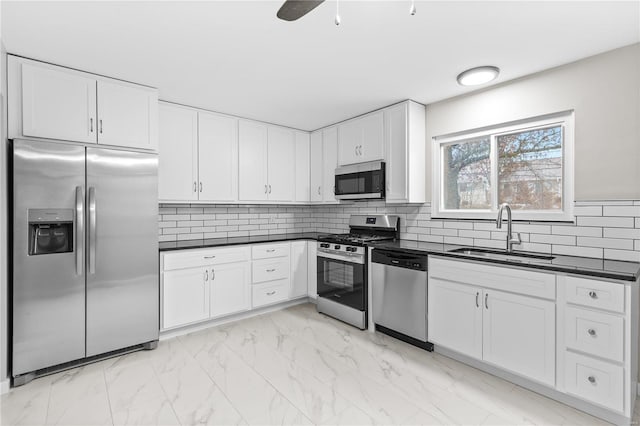 kitchen with white cabinetry, stainless steel appliances, sink, and tasteful backsplash