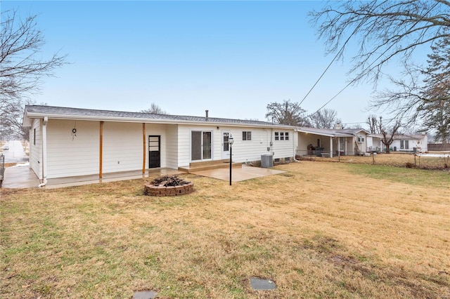 rear view of house featuring a fire pit, a lawn, central air condition unit, and a patio area