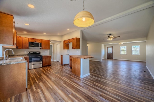 kitchen featuring sink, vaulted ceiling, dark hardwood / wood-style floors, ceiling fan, and stainless steel appliances