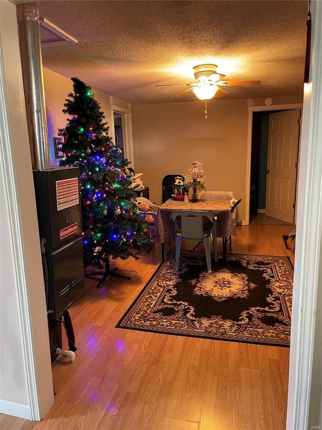 dining room with a textured ceiling, hardwood / wood-style flooring, and ceiling fan