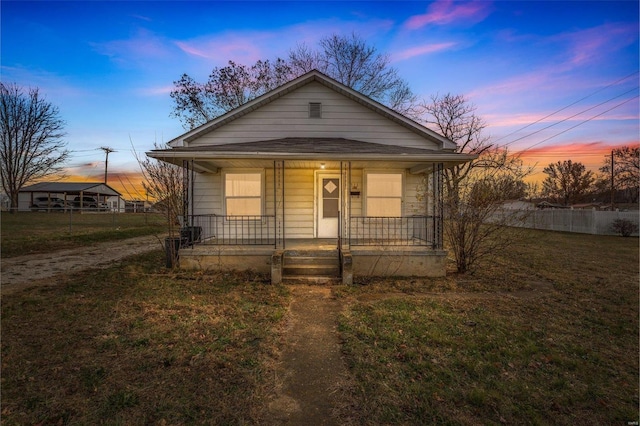 bungalow-style house with a lawn and covered porch