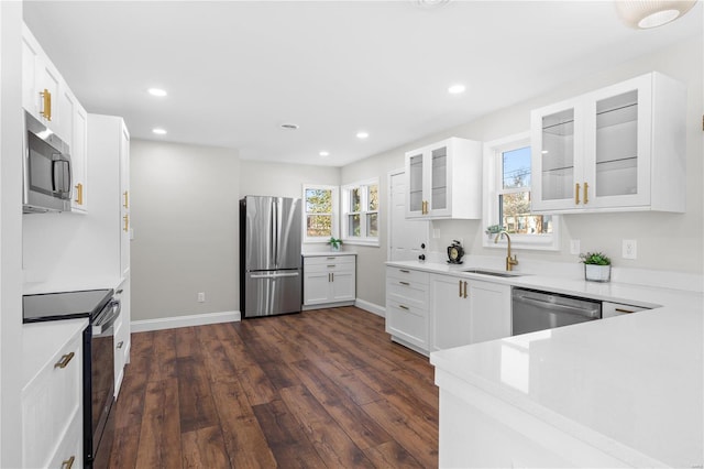 kitchen featuring dark hardwood / wood-style flooring, white cabinetry, sink, and appliances with stainless steel finishes