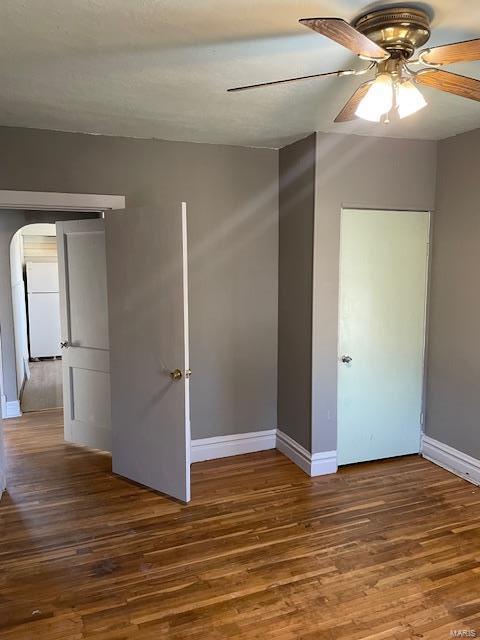 empty room featuring ceiling fan and dark hardwood / wood-style flooring