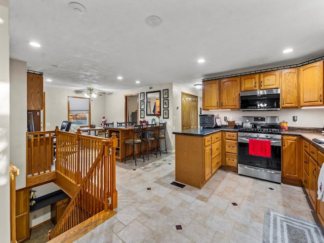 kitchen with kitchen peninsula, ceiling fan, and stainless steel appliances