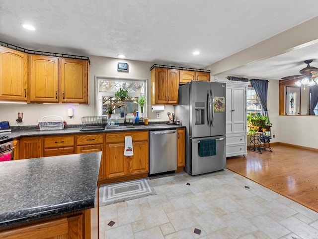 kitchen featuring ceiling fan, sink, light wood-type flooring, and appliances with stainless steel finishes