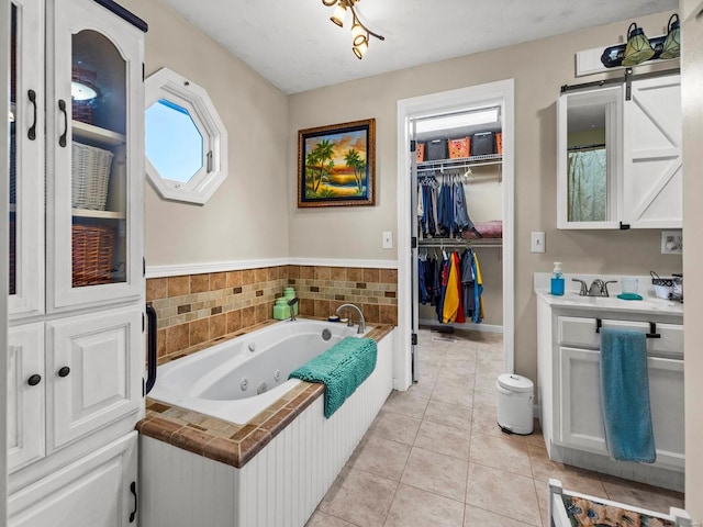 bathroom with tile patterned floors, a tub, and vanity