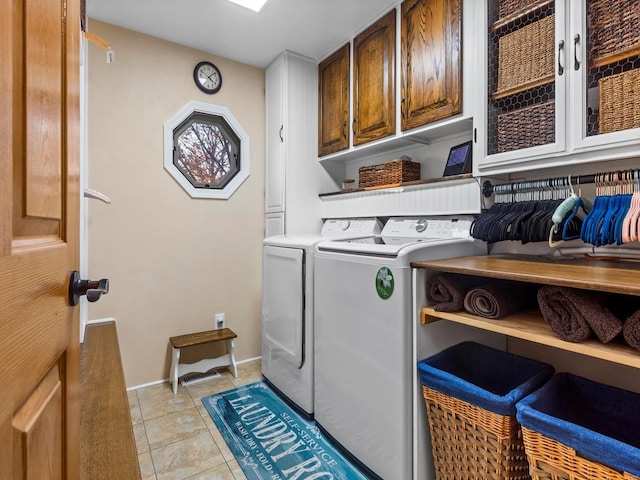 laundry area with cabinets, independent washer and dryer, and light tile patterned flooring