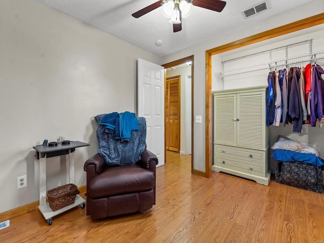 sitting room with ceiling fan and light hardwood / wood-style floors