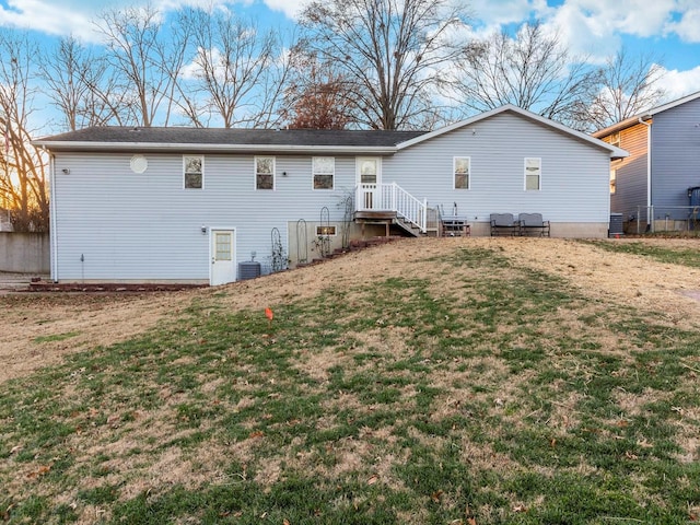 rear view of property featuring central AC unit and a yard