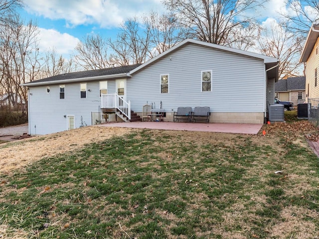 back of property with central air condition unit, a lawn, and a patio