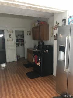 kitchen with stainless steel fridge and hardwood / wood-style flooring