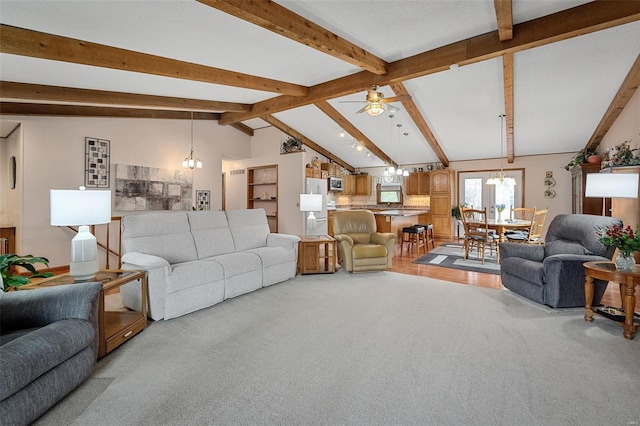 living room with ceiling fan with notable chandelier, lofted ceiling with beams, and light hardwood / wood-style floors