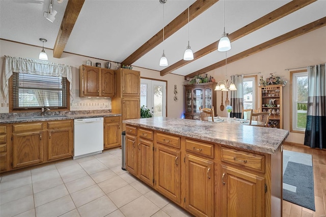 kitchen featuring sink, pendant lighting, dishwasher, vaulted ceiling with beams, and a kitchen island