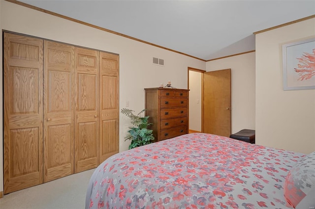 bedroom featuring a closet, carpet floors, lofted ceiling, and ornamental molding