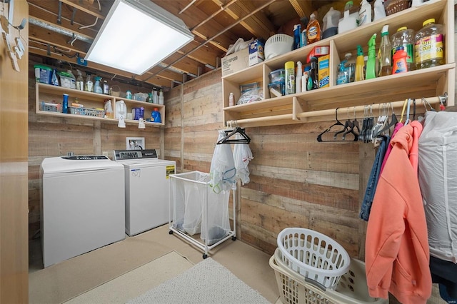 laundry area featuring washing machine and clothes dryer and wooden walls