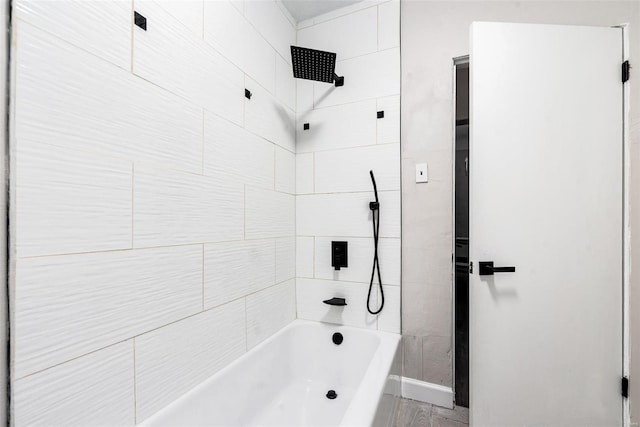 bathroom featuring wood-type flooring and tiled shower / bath