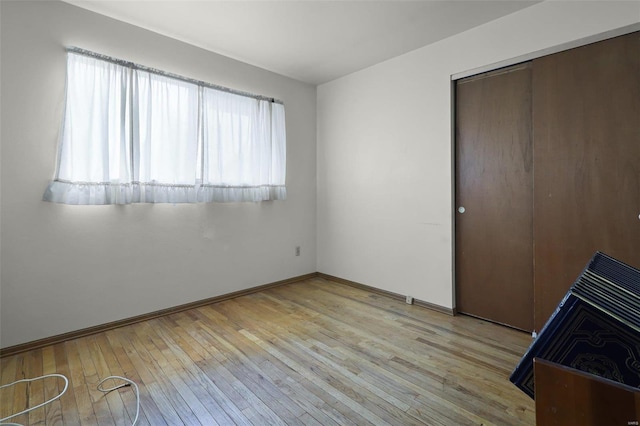 unfurnished bedroom featuring a closet and light hardwood / wood-style floors