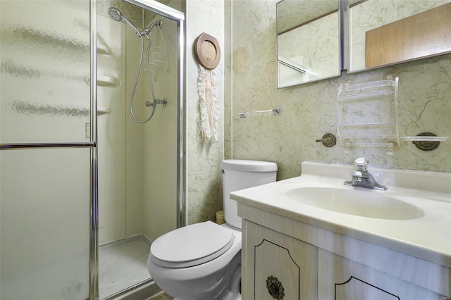 bathroom featuring vanity, a shower with shower door, and toilet