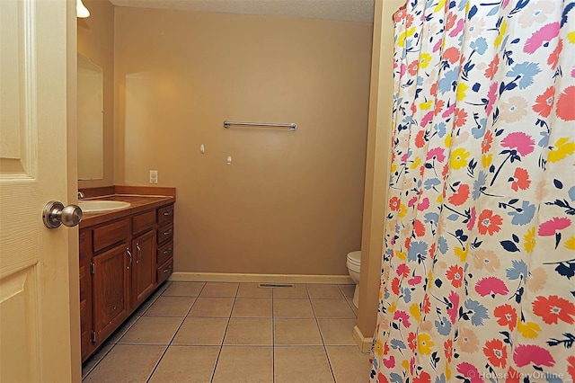 bathroom with tile patterned flooring, vanity, toilet, and a textured ceiling