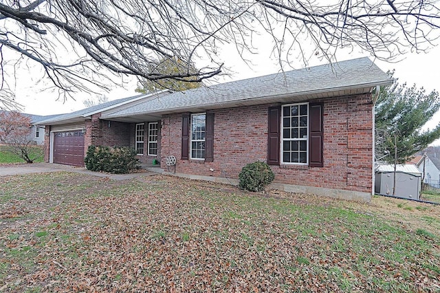 view of front facade with a garage, a storage shed, and a front lawn