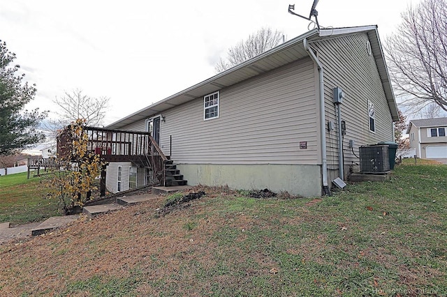 view of home's exterior with a wooden deck, a yard, and central AC unit