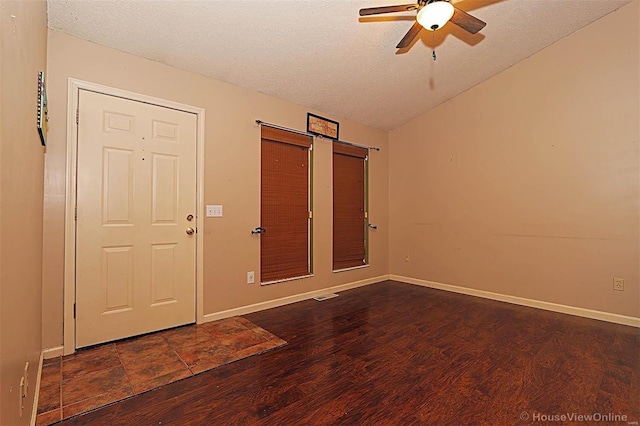 interior space with a textured ceiling, dark hardwood / wood-style flooring, vaulted ceiling, and ceiling fan