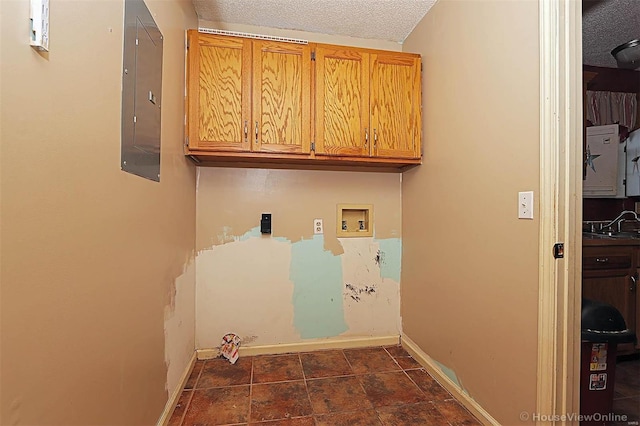 laundry area featuring cabinets, hookup for a washing machine, a textured ceiling, and electric panel