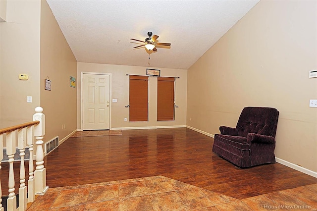 living area featuring ceiling fan, wood-type flooring, and a textured ceiling