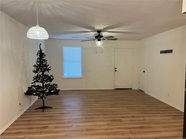 interior space with ceiling fan, hardwood / wood-style floors, and a textured ceiling