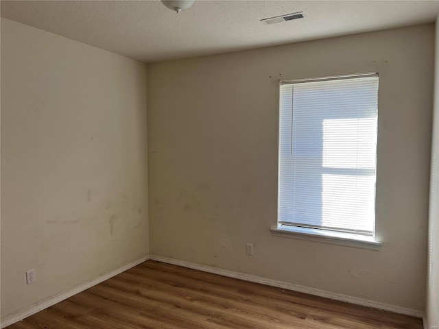 unfurnished room featuring a textured ceiling and hardwood / wood-style flooring