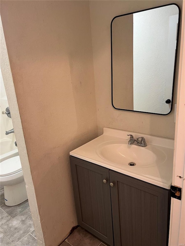 bathroom with tile patterned flooring, vanity, and toilet