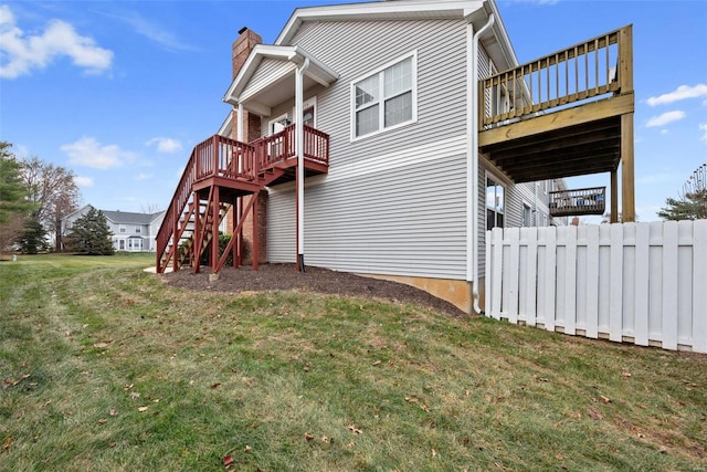 back of house featuring a lawn and a wooden deck