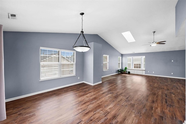 unfurnished living room featuring dark hardwood / wood-style flooring, ceiling fan, and vaulted ceiling with skylight