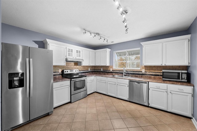 kitchen featuring decorative backsplash, appliances with stainless steel finishes, white cabinetry, and sink