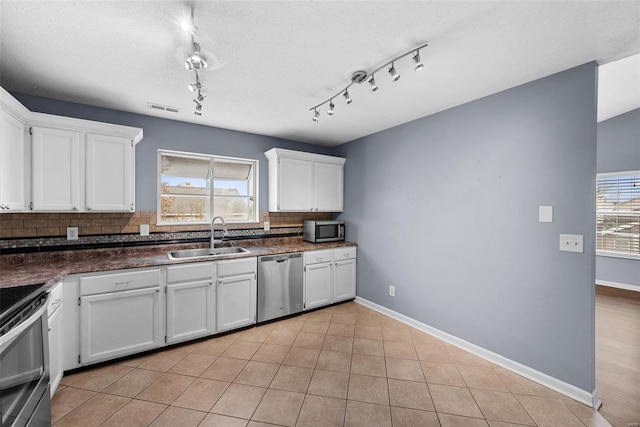 kitchen featuring backsplash, stainless steel appliances, white cabinetry, and sink