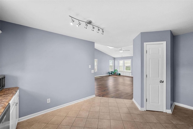 interior space with vaulted ceiling with skylight and light tile patterned flooring