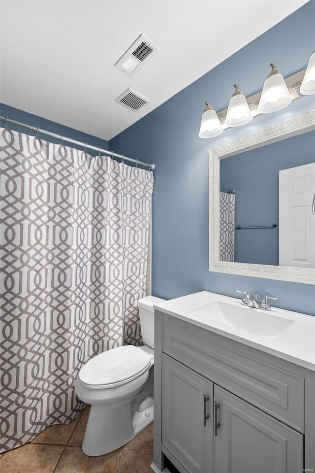 bathroom with tile patterned flooring, vanity, and toilet